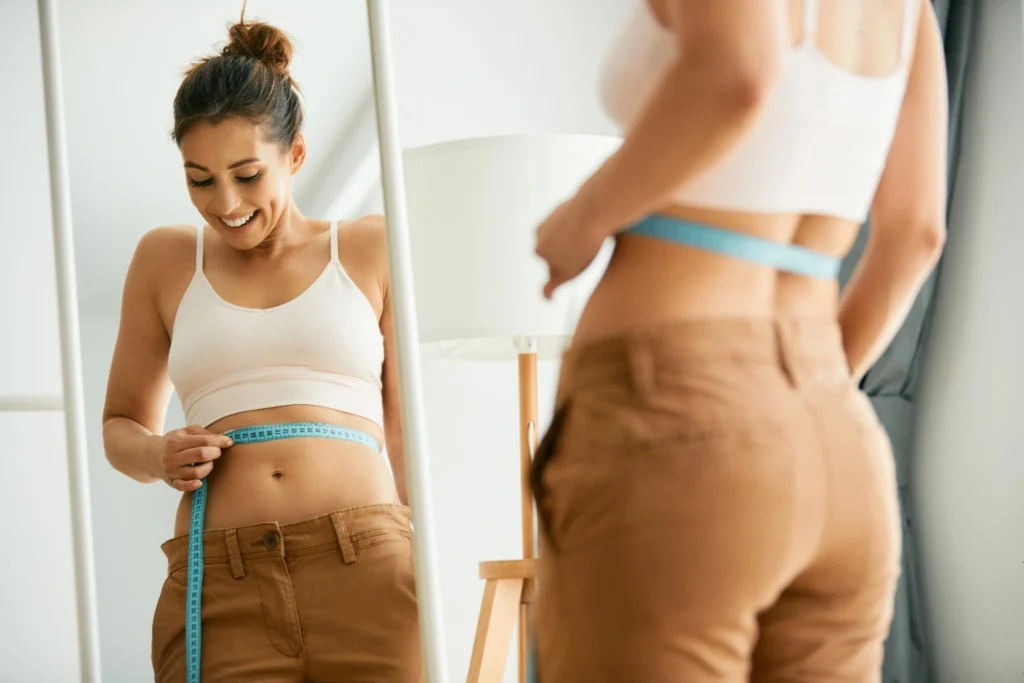 Women Measuring tummy after Weight Loss Program by Rejuven8 Medical