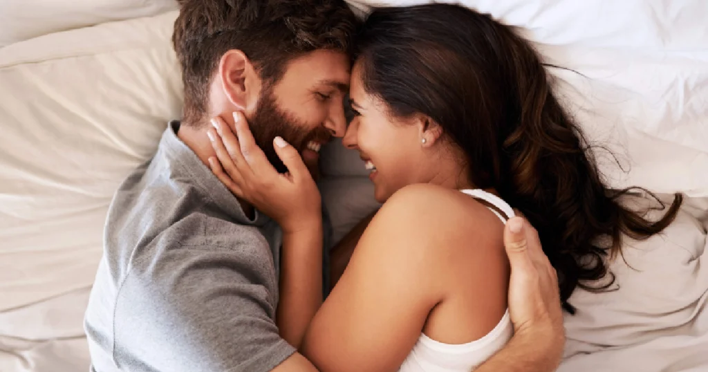 Current image: Happy couple embracing in bed, smiling and enjoying representing improved confidence and connection after P-Shot Therapy in Sugar Land, TX.