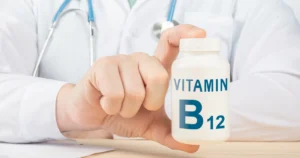 A doctor in a white coat holding a bottle of Vitamin B12 supplements, representing a Weight Loss Program in Sugar Land, TX.